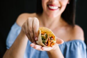 Woman eating tacos a great meal idea when it's too hot to cook.